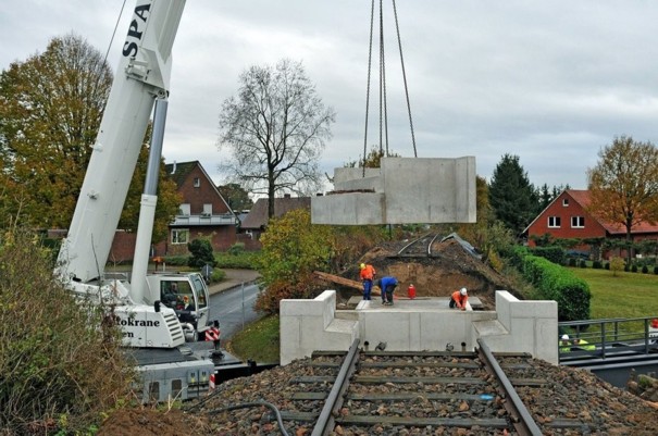 Einheben eines 30 Tonnen schweren Betonwiderlagers am Brückenbauwerk "Schulstraße" in Bad Iburg - Glane